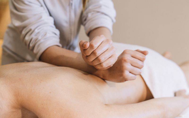 Chuyên viên đang thực hiện kỹ thuật massage sâu trên lưng của bệnh nhân