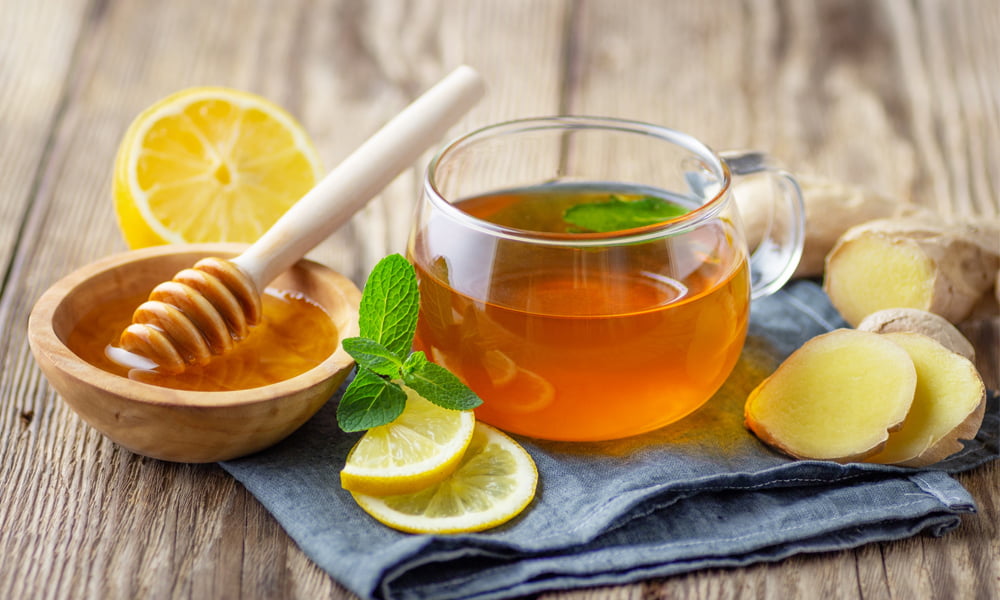 Pha trà gừng, mật ong với nước ấm để uống giúp làm dịu cơn đau bụng dưới